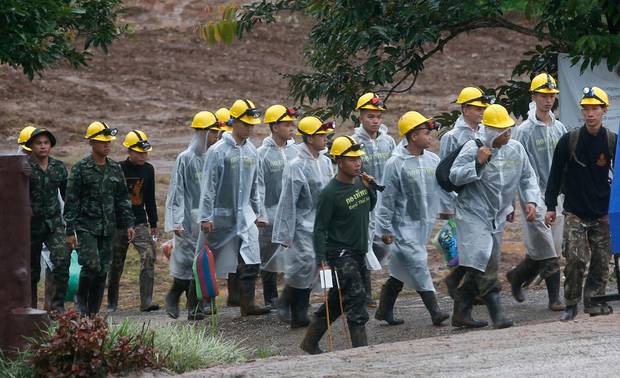 Rescuers walk toward the entrance to a cave complex where five were still trapped. Photo / AP