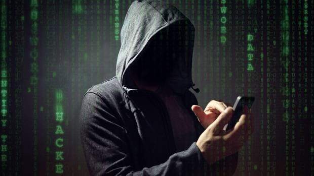 Computer hacker with mobile phone smartphone stealing data