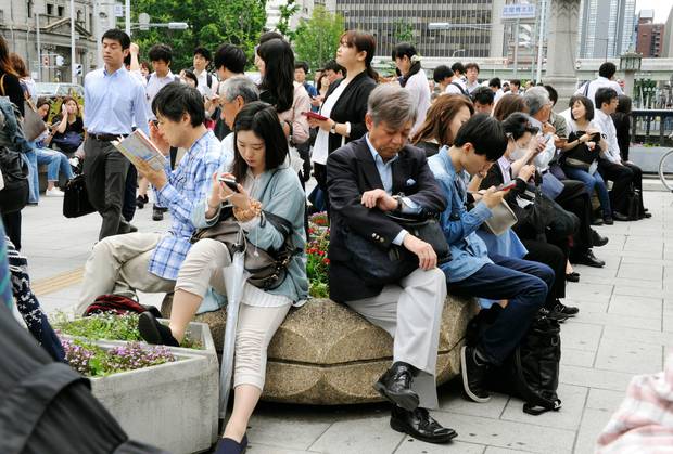 People wait for train service to resume following an earthquake in Osaka. Photo / AP