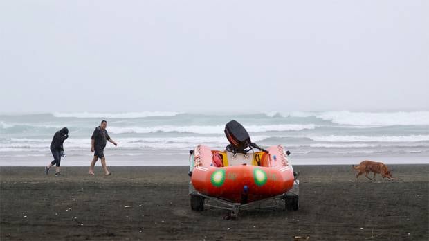 Bethell's Beach goers leave after a large down pour, the rain emptied the beach within minutes on Sunday afternoon. Photo / Greg Bowker