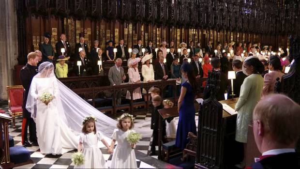 In this frame from video, Britain's Prince Harry and Meghan Markle watch as the bridesmaids and page boys walk down the aisle at their wedding ceremony at St. George's Chapel. Photo / AP