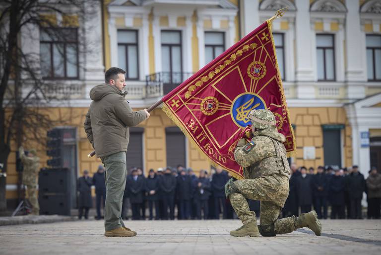 Ukrainian President Volodymyr Zelensky holds the flag of a military unit as an officer kisses it during a commemorative event in Kyiv, Ukraine on the one-year anniversary of the Russia-Ukraine war. Photo / AP