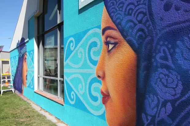 Auckland street artist Erika Pearce has spent the last five days piecing together the culturally diverse mural on the side of Hastings Library. Photo / Paul Taylor
