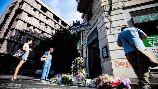 People stop by flowers and messages left on the spot in Rome where police officer Mario Cerciello Rega was stabbed to death early Friday. Photo / AP