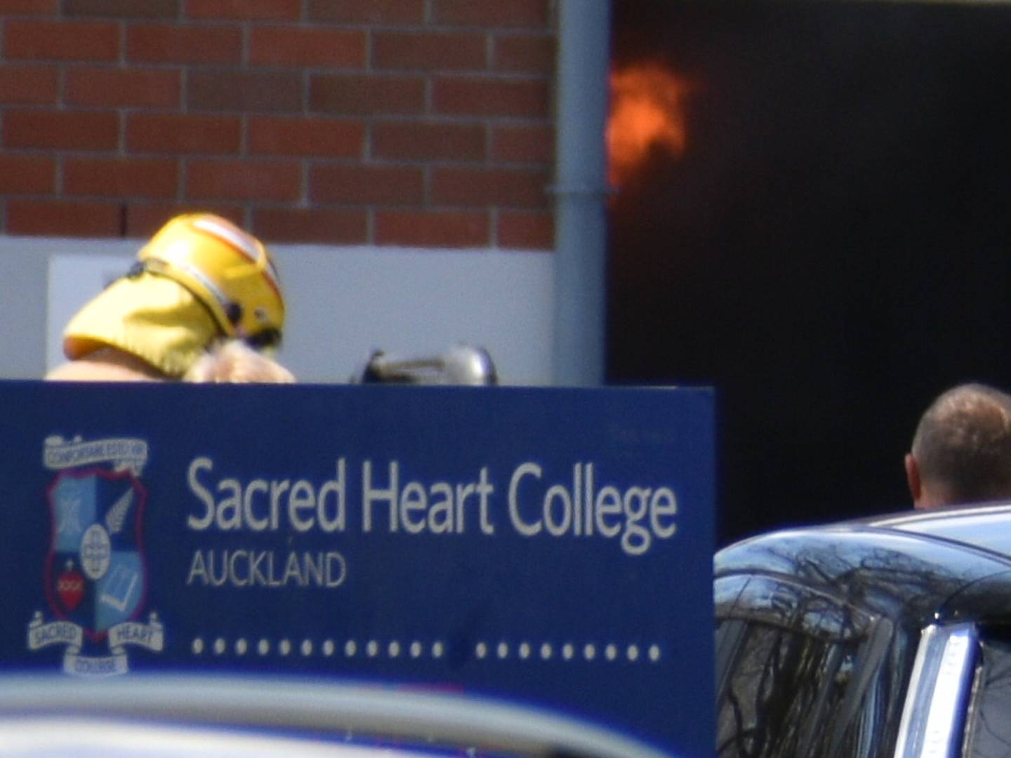 Flames can be seen as firefighters respond to Sacred Heart College in Glendowie. Photo / Darren Masters