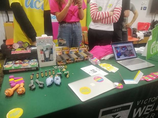 Photos of Young Act's O-week stall at the University show boxes of Shesha on display next to smoking devices - commonly used for consuming marijuana - and cannabis grinding devices. 