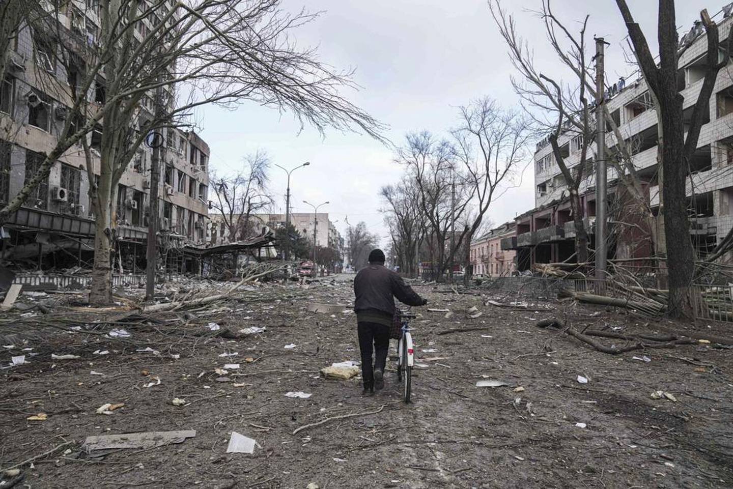乌克兰马里乌波尔，一名男子骑着自行车在被炮击毁坏的街道上行走。 照片/美联社