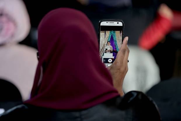 A member of the crowd takes the Prime Minister's photograph. photo / Michael Craig
