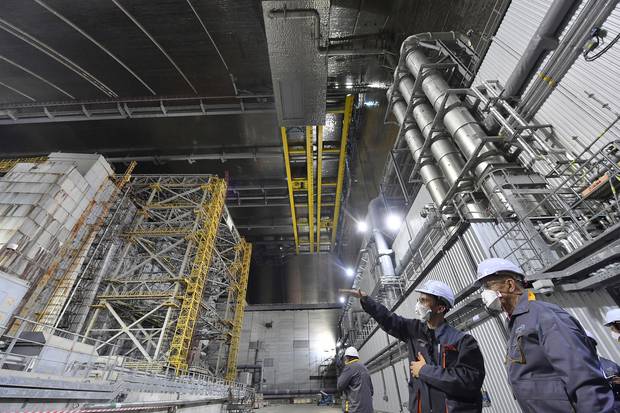 French Foreign Minister Jean-Yves Le Drian, right, listens to an employee inside Chernobyl's New Safe Confinement shelter. Photo / AP