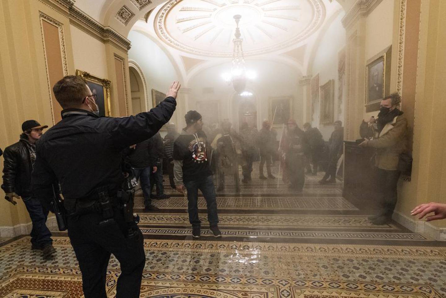 Smoke fills the walkway outside the Senate Chamber as supporters of President Donald Trump are confronted by U.S. Capitol Police officers inside the Capitol in Washington. Photo / AP