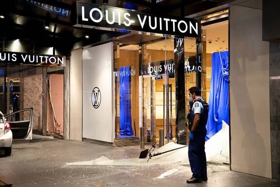 A police officer stands outside the Louis Vuitton and Gucci stores in downtown Auckland. Photo / Hayden Woodward