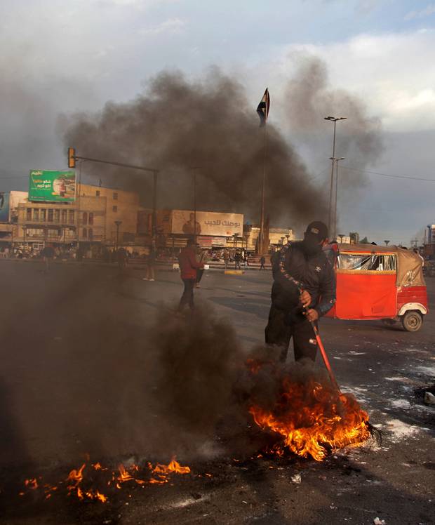 Anti-government protesters set fires to close a street near Tahrir Square in Baghdad yesterday to protest the Iranian missile strike that targeted two military bases in Iraq. Photo / AP