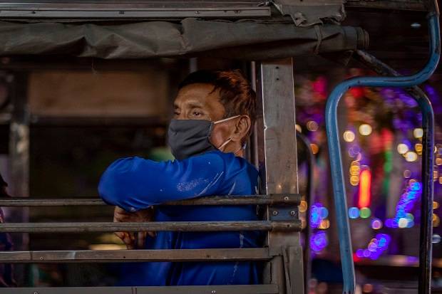 A migrant construction worker wearing a face mask travels in a truck Bangkok, Thailand. Photo / AP