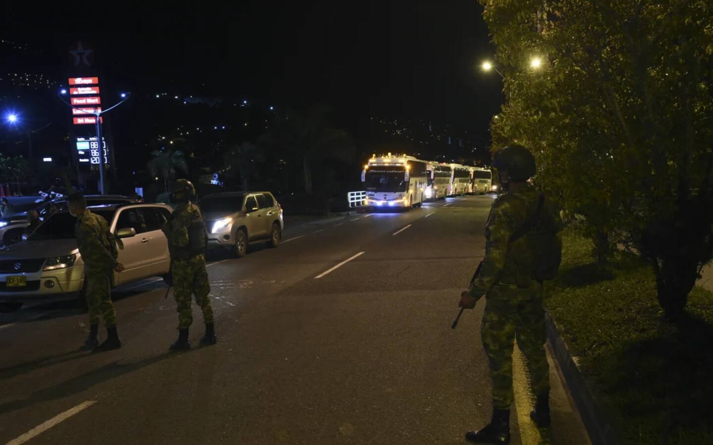 Colombian soldiers stand guard as the caravan carrying former FARC guerillas stopped at a gas station while heading to Mutata, Antioquia department, Colombia, on July 16, 2020 after being evacuated from the Territorial Area of Training and Reincorporation (ETCR) of Santa Lucia near Ituango. Photo / AFP