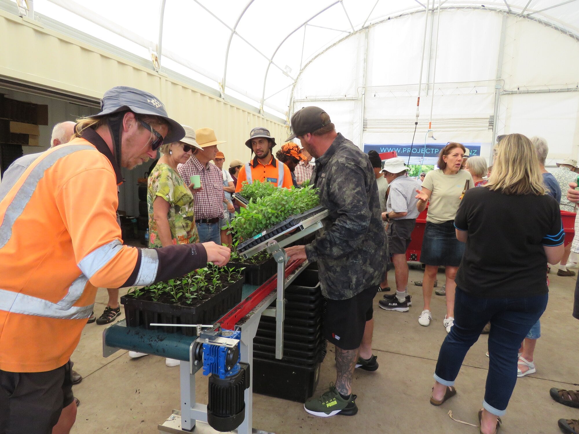  Logan Brewer helps his crew show guests at Project Parore’s base launch how the new tray filling machine works. Photo / Merle Cave