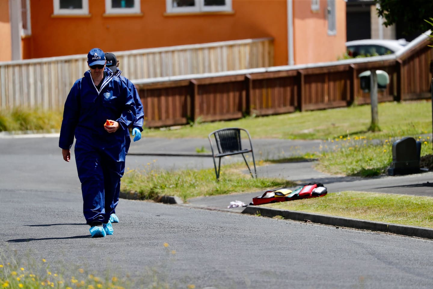 Police forensics staff on a Hamilton street, where a baby was killed, and two others seriously injured. Photo / Dean Purcell