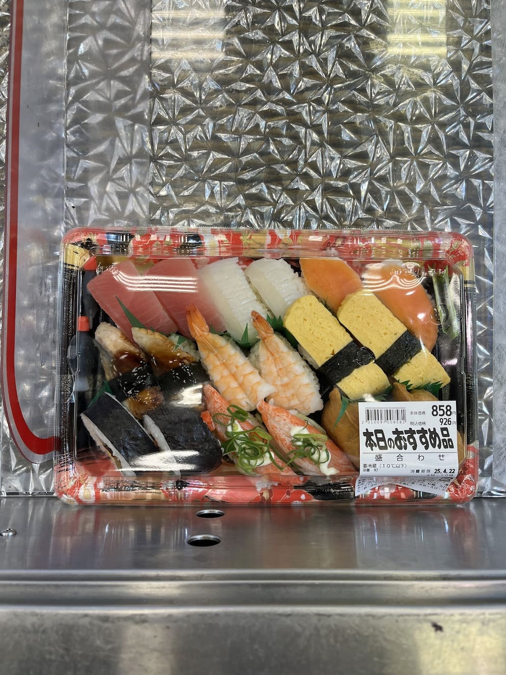 A person selecting food from a supermarket deli
