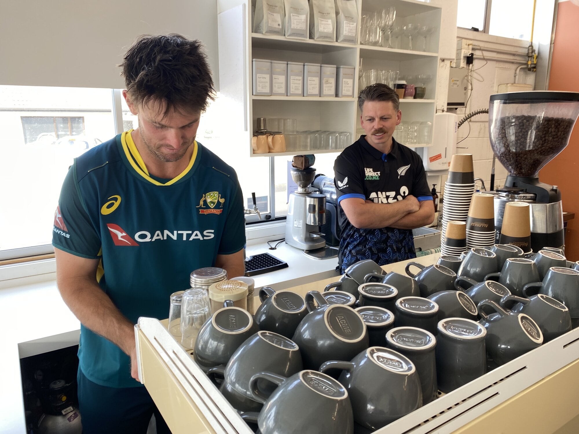  Australian captain Mitch Marsh making a latte at Somethin' Somethin' in Heath St, with BLACKCAPS captain Michael Bracewell looking on. Photo / Rosalie Liddle Crawford