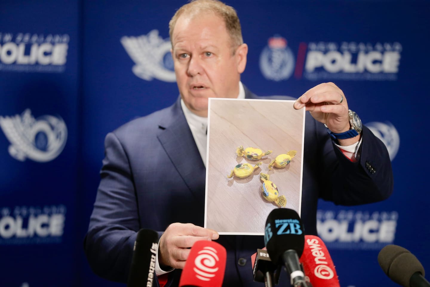 Detective Inspector Glenn Baldwin holds up a photo of the Rinda-branded meth-laced lollies found in food parcels given to needy families. Photo / Alex Burton