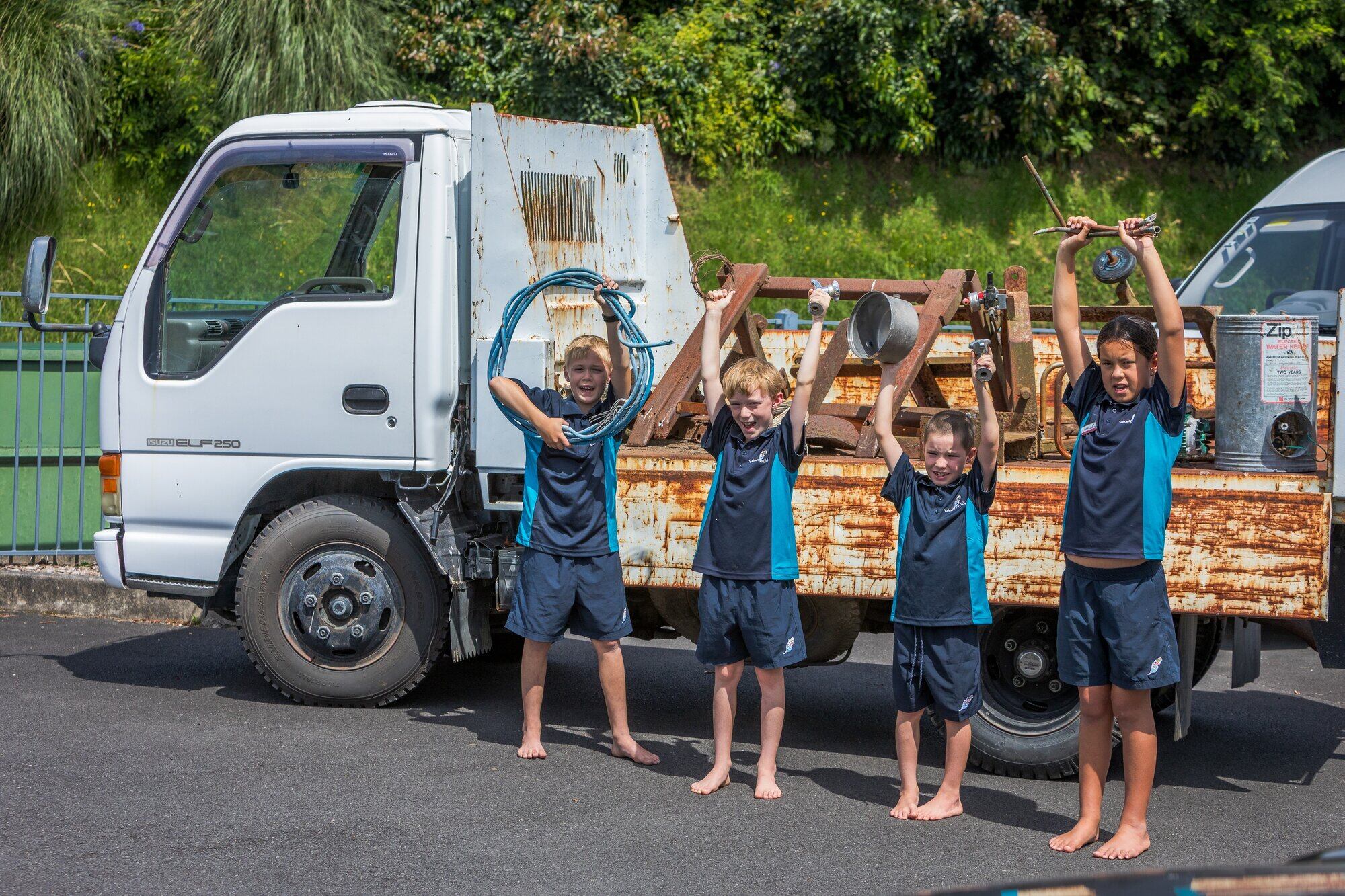  Welcome Bay students Dylan Beaver, 10, Thomas Beaver, 8, Kade Eason, 7, and Amaiya Jones, 10, in front of a scrap metal truck ready to collect donations on March 6. Photo / Kelly O&rsquo;Hara