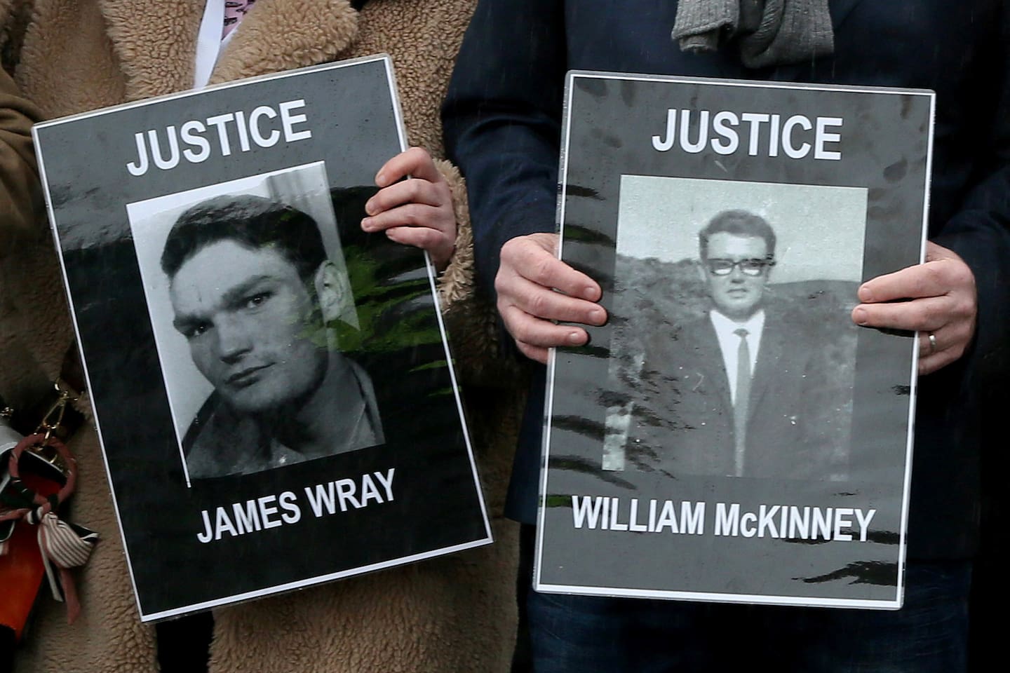 Relatives and supporters of the victims of the 1972 'Bloody Sunday' killings hold images of James Wray and William McKinney. Photo / Paul Faith, AFP