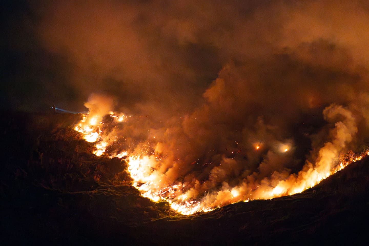 Firefighters from across Auckland were battling a large fire on Māngere Mountain in South Auckland overnight. Photo / Hayden Woodward