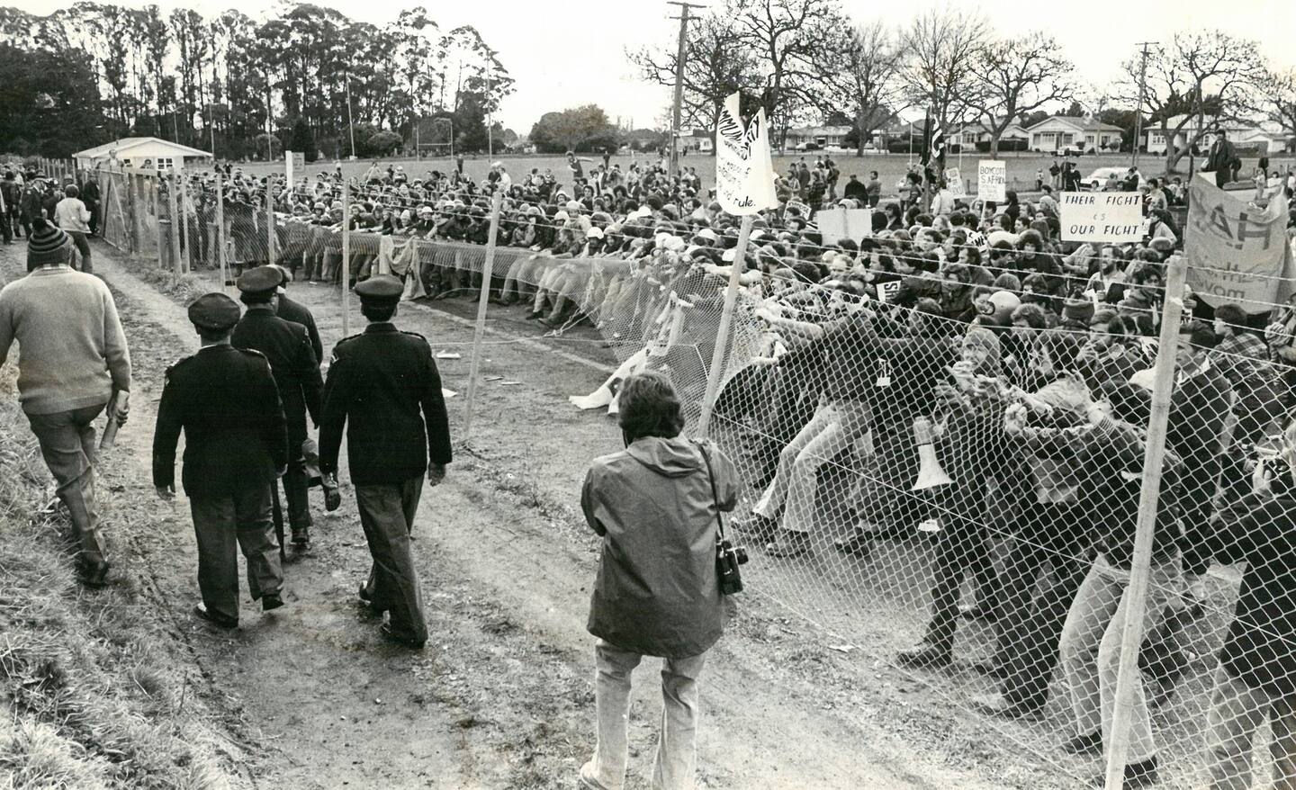 Determined members of the protest movement tear down the fence surrounding Hamilton's Rugby Park before storming the playing surface. Photo / NZ Herald