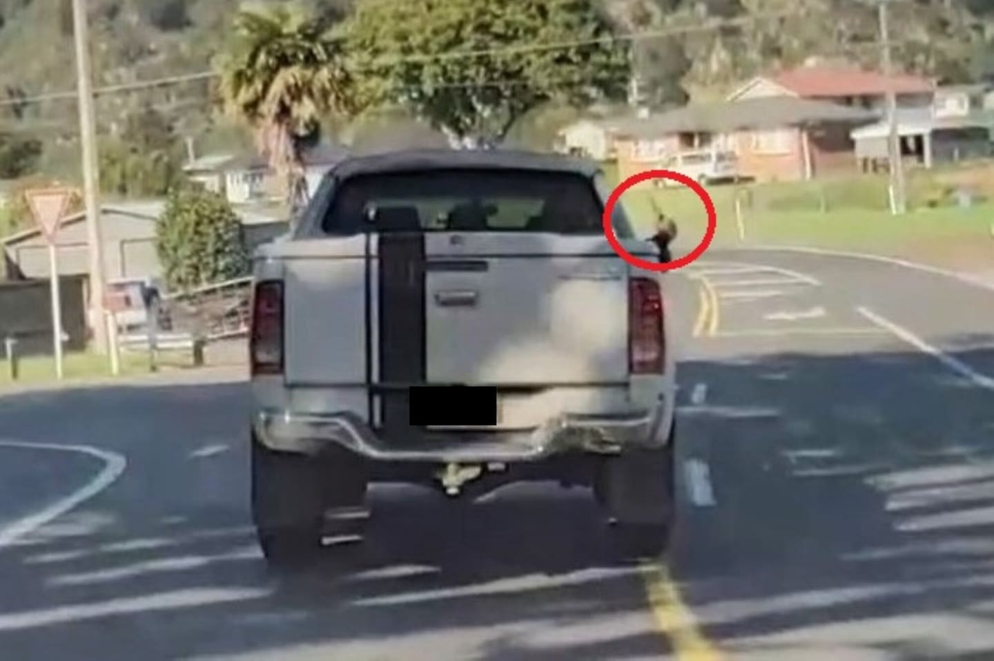 A ute driver holds a knife out of his window during the incident in Welcome Bay.