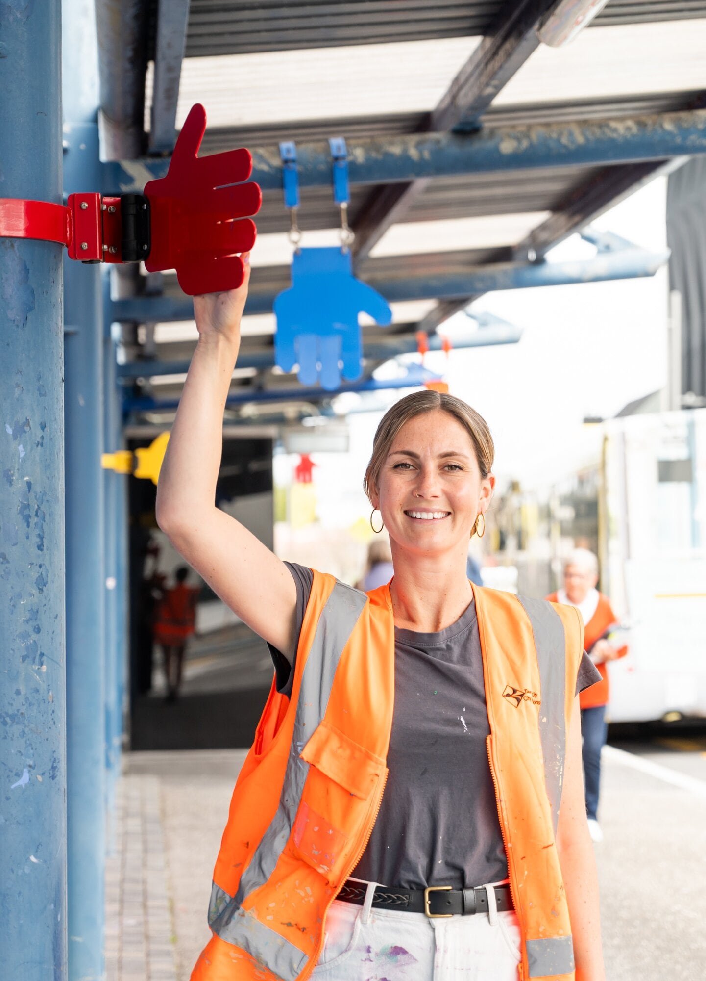  Sarah Jo Cornish with the ‘high five’ hands installation hanging above the pavement at the corner of Spring St and Durham St. Photo / Brydie Thompson