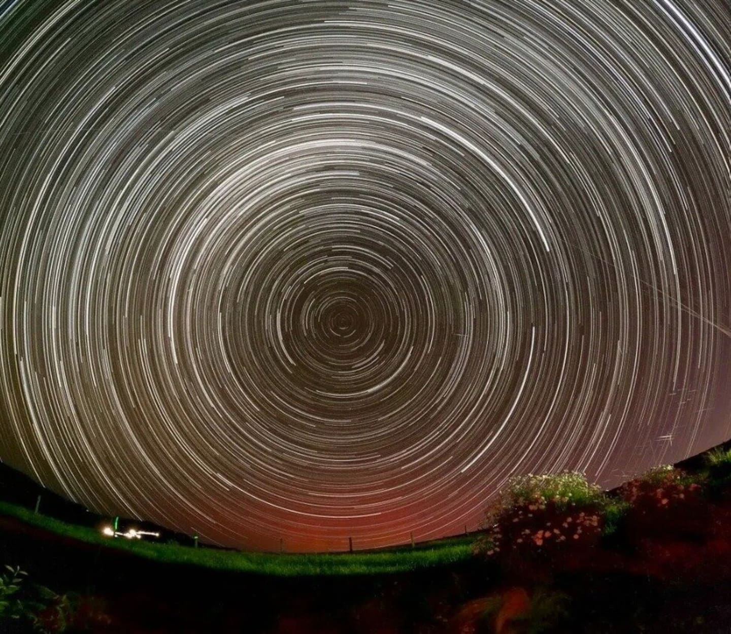 A long exposure image of the night sky from Star Safari Observatory in Carterton showing stars as concentric circles, with satellites visible as short lines in the lower right quadrant. Photo / Supplied