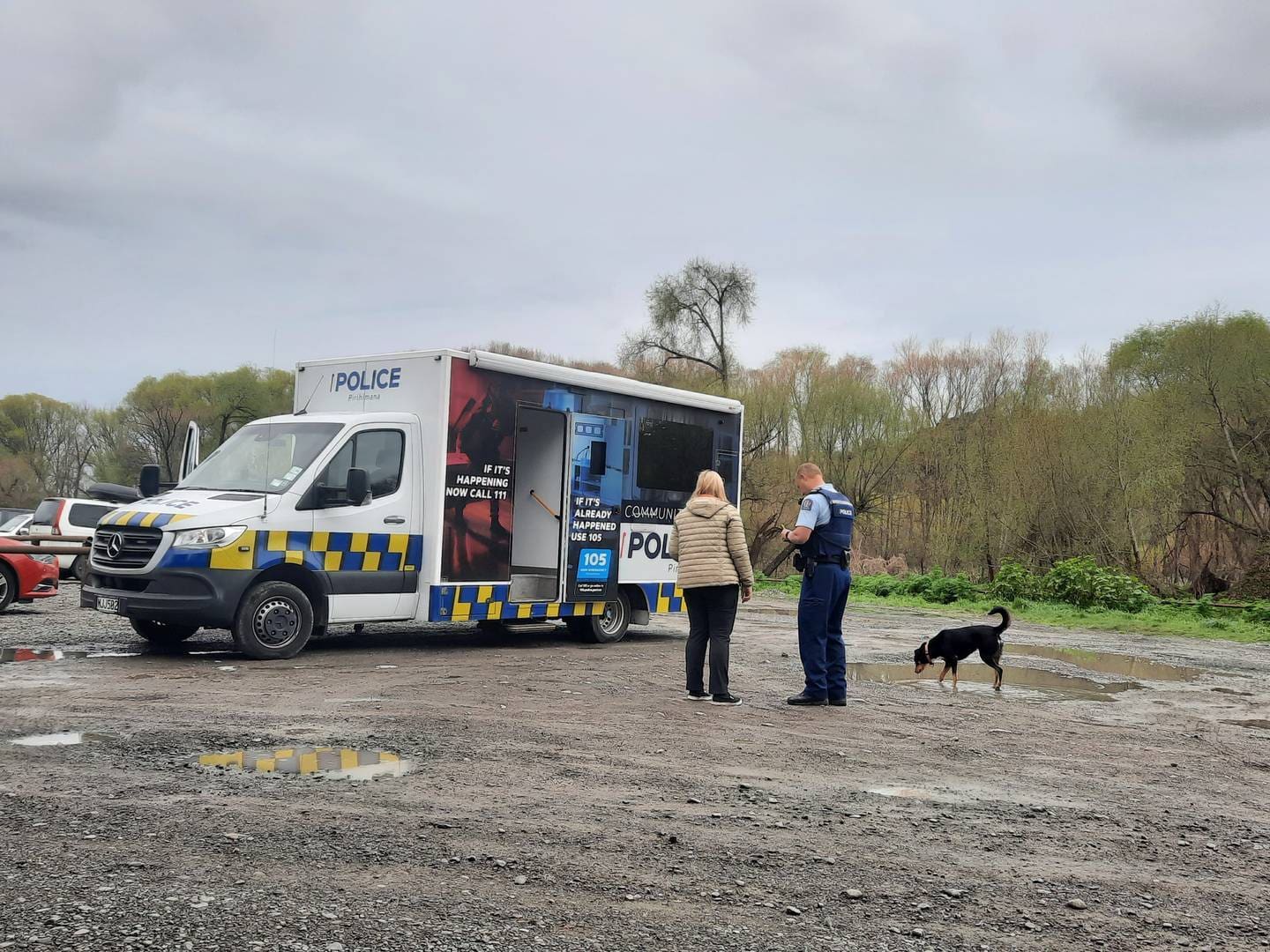 A police officer talks to a dog walker at the River Road Recreational Reserve a week after Ariki Rigby's body was found. Photo / Neil Reid