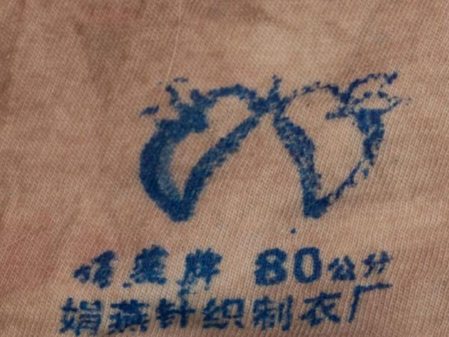 Police investigating the murder of an Asian woman whose body was found at Gulf Harbour released this photo of branding on a singlet found on the body. Photo / NZ Police