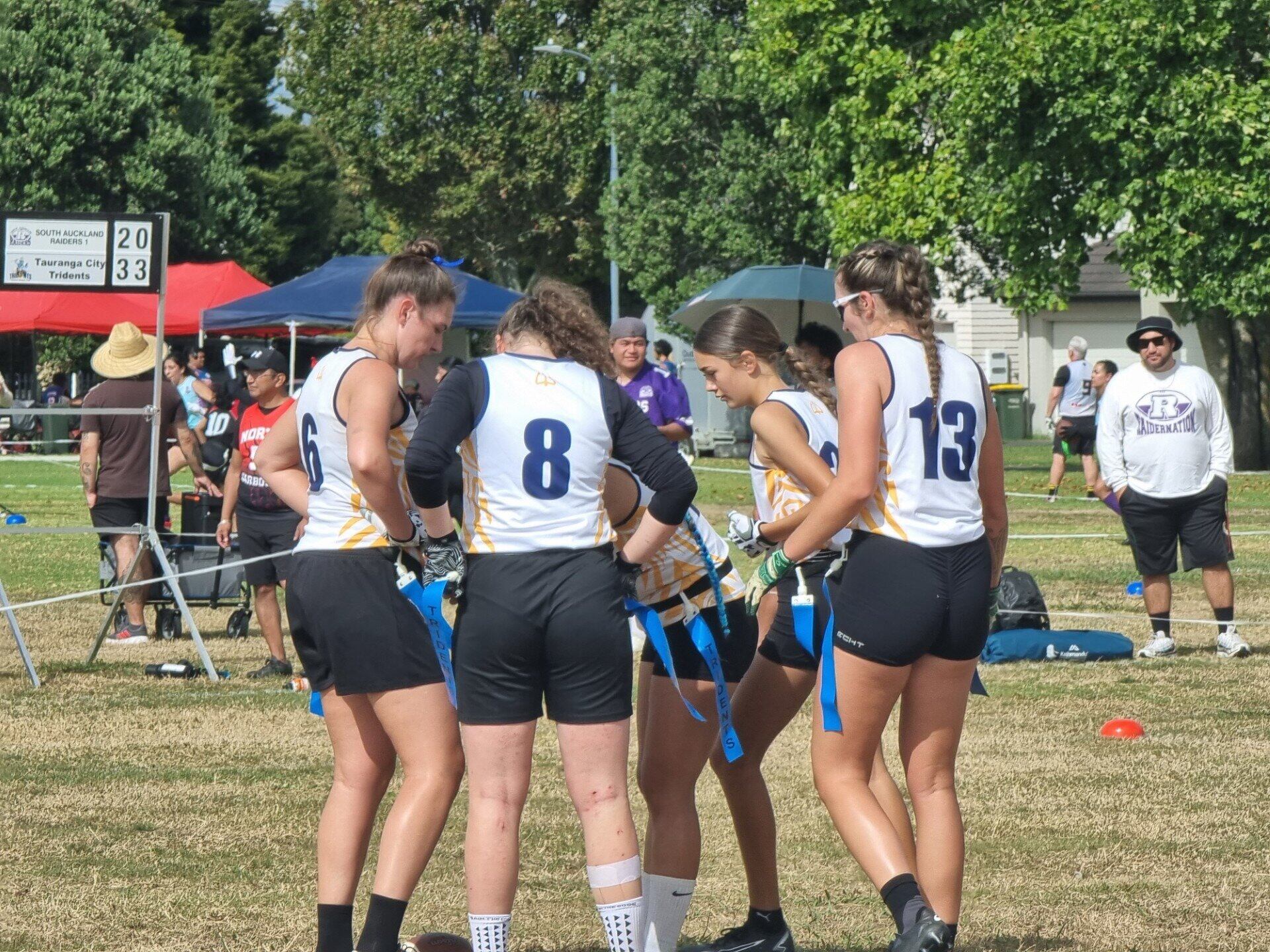  Tridents women players in a huddle at the 2025 National Flag Football champs. Photo / Supplied