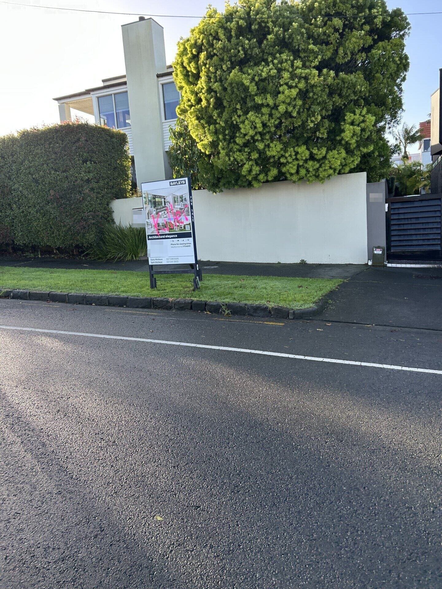 The double-storey home in Remuera that belonged to Philip Polkinghorne and his late wife Pauline Hanna. The real estate sign was seen vandalised on Friday morning with the word "Killer" in hot pink spraypaint.
