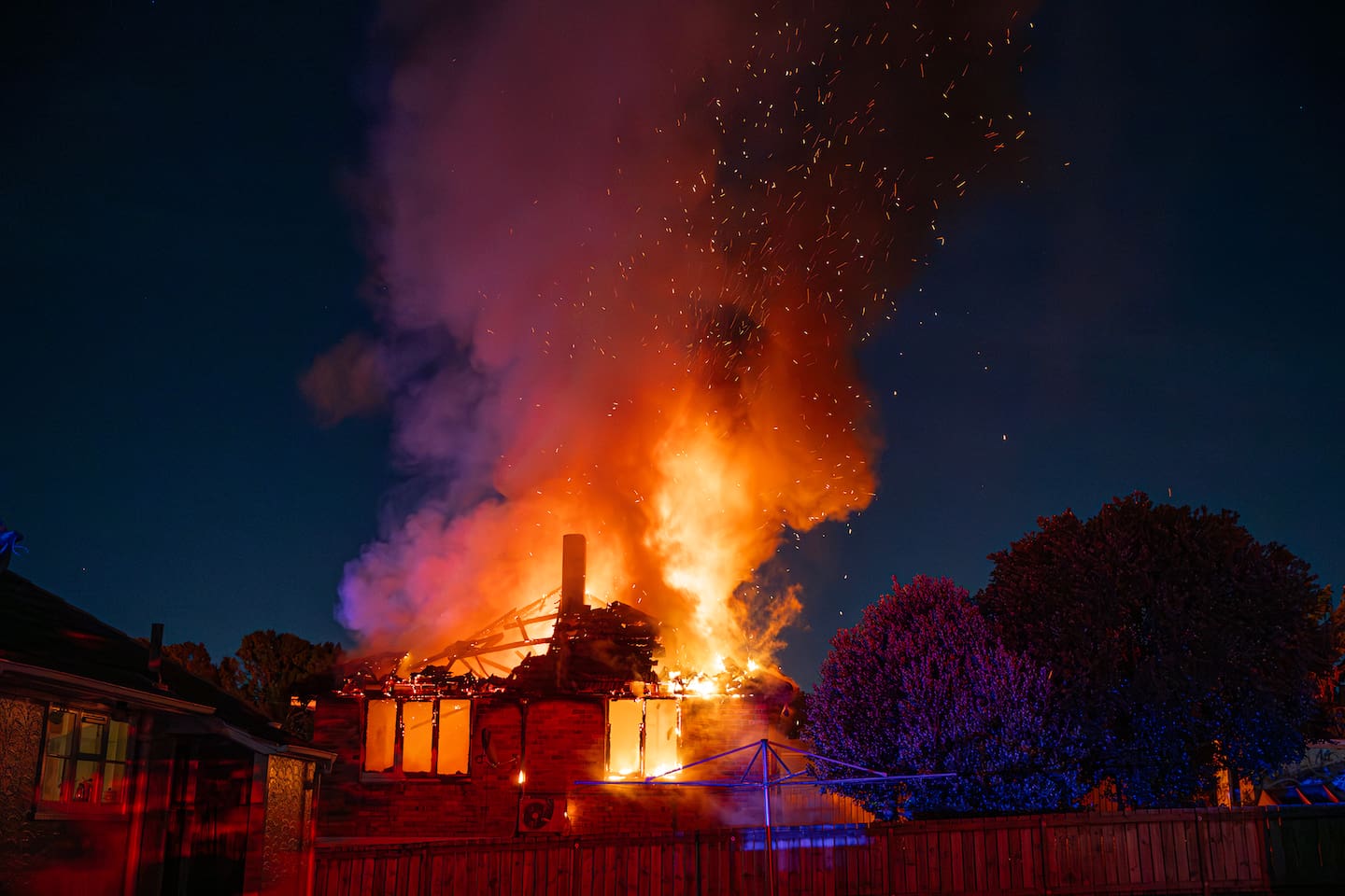 A woman was taken away in handcuffs after attempting to run back into the Panmure house. Photo / Hayden Woodward