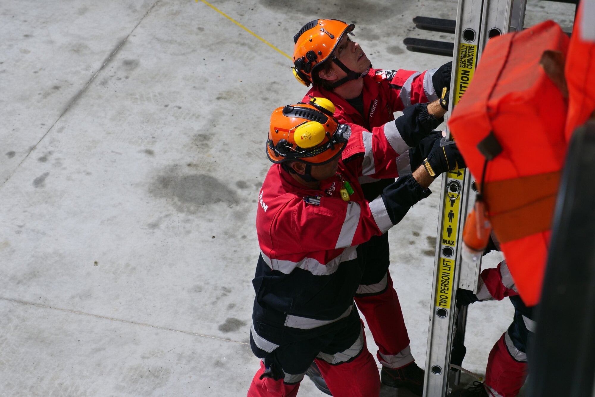  Members of NZRT16 get ready on the ladder as the stretcher is lowered to the ground.