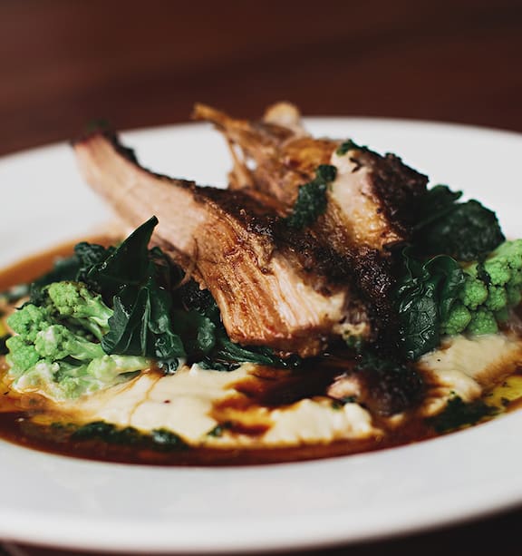 Slow-roast pork with jerusalem artichoke puree, winter greens and