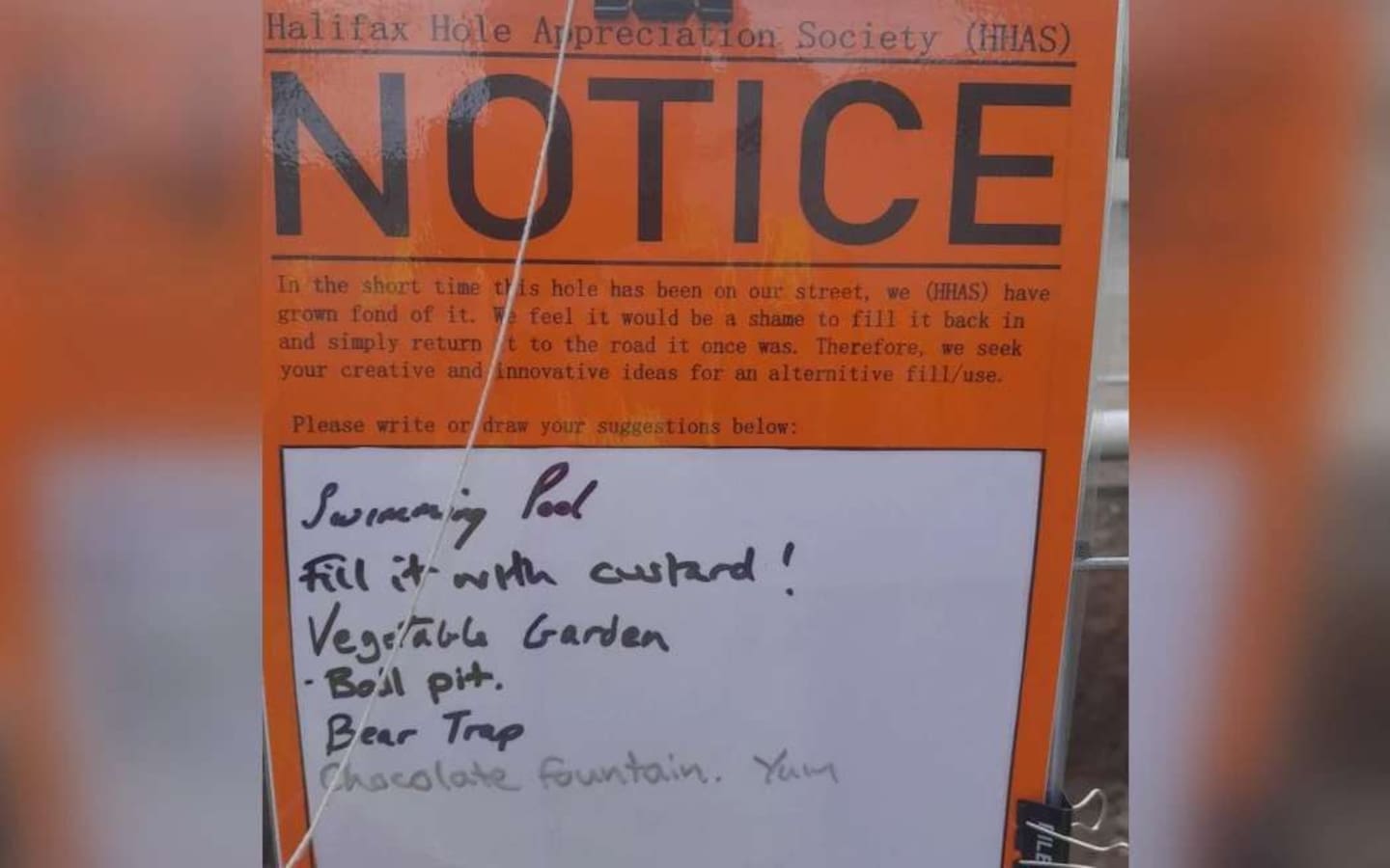 A notice from the "Halifax Hole Appreciation Society (HHAS)" that was affixed to temporary fencing around the Halifax St East sinkhole in Nelson. Photo / Nelson City Council