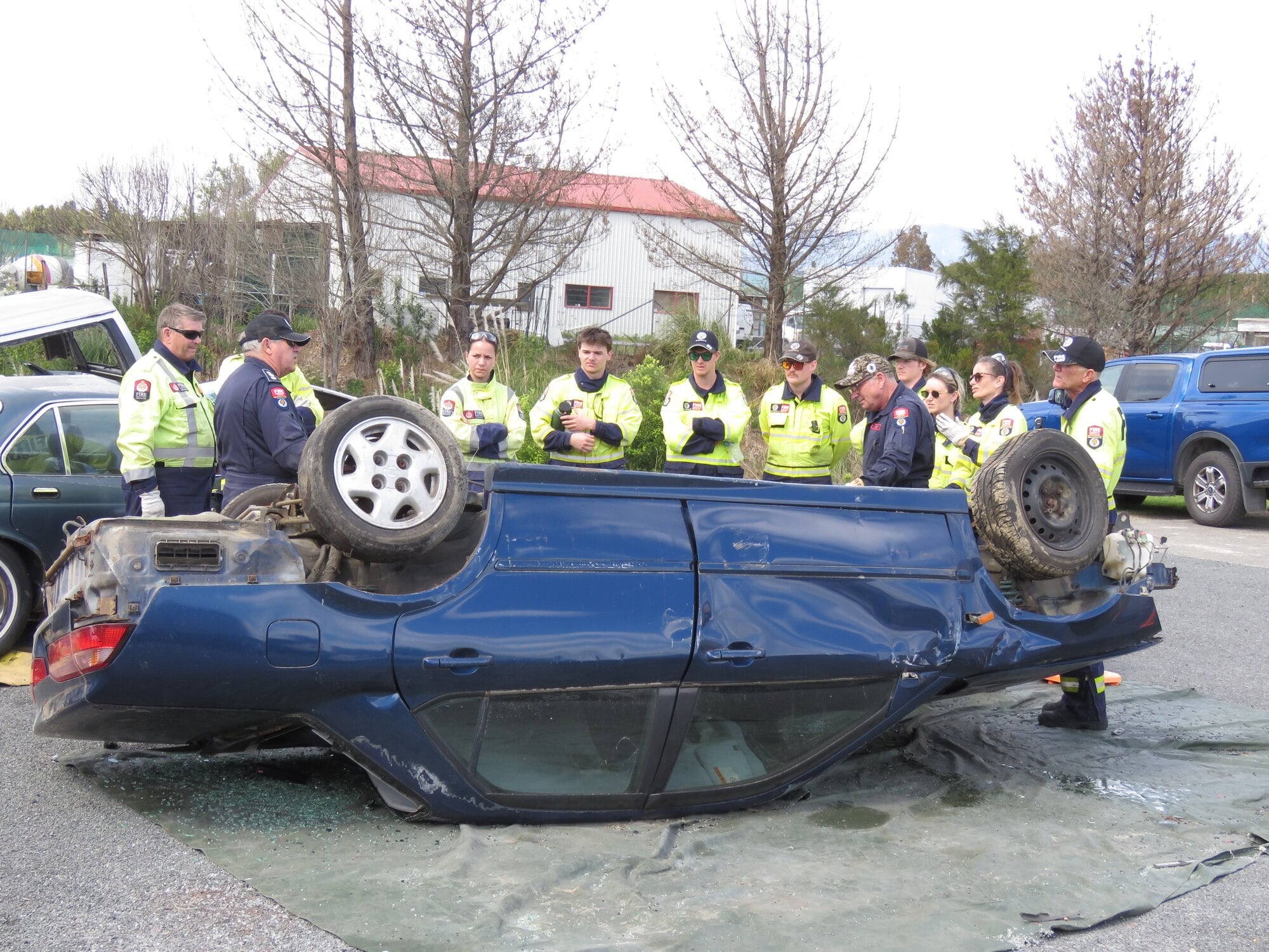  Two Fire Emergency New Zealand’s National Training Centre tutors discuss with MVE course firefighters an extrication plan before helmets go on to undertake the work. Photo / Merle Cave