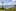 Kiwi-as: Cabbage trees and red hot pokers frame the view over Onetangi Beach, on Waiheke Island. Photo / Supplied