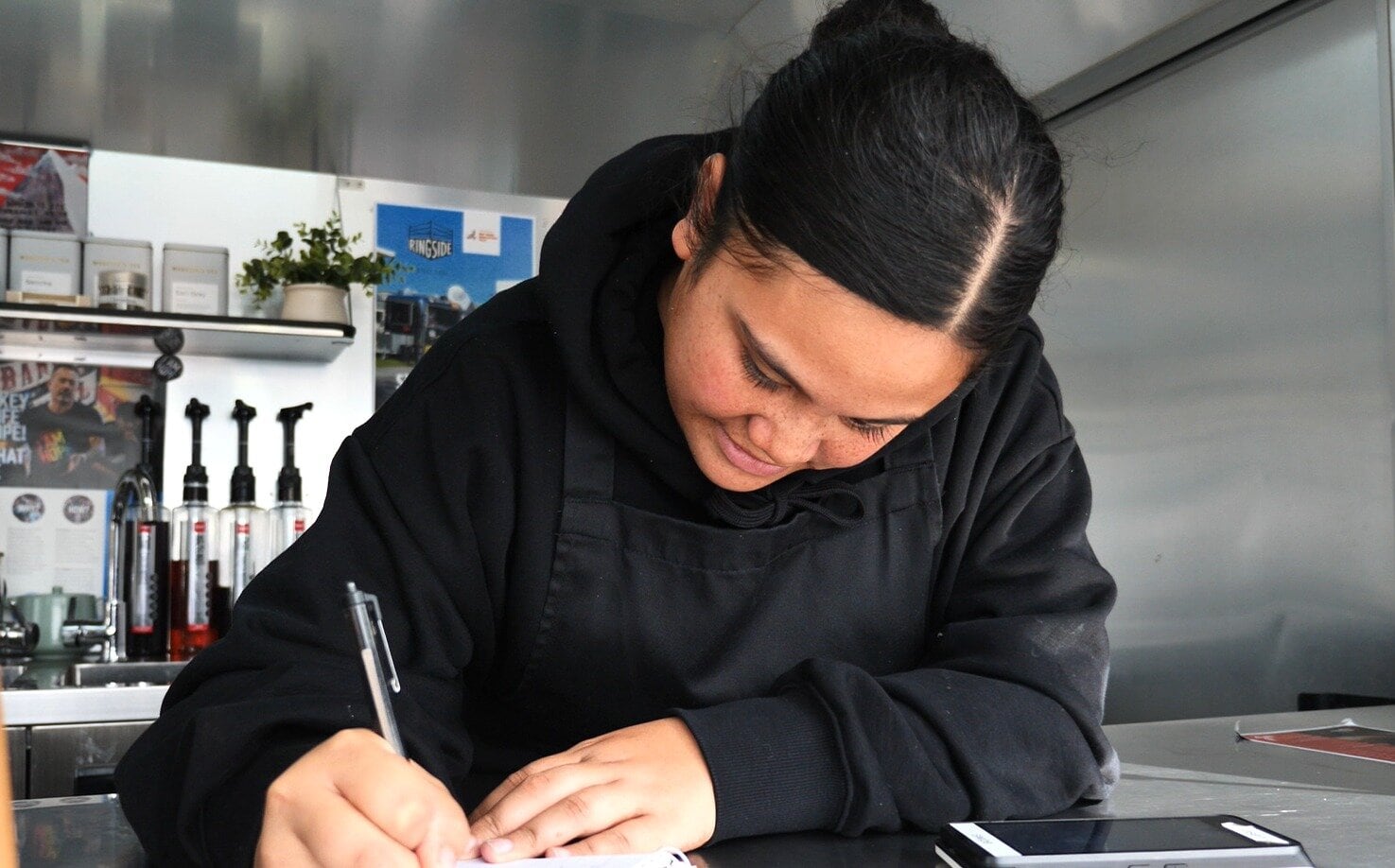  Hiraka Hiku takes the orders and Nataleah Taratoa makes the coffee.
