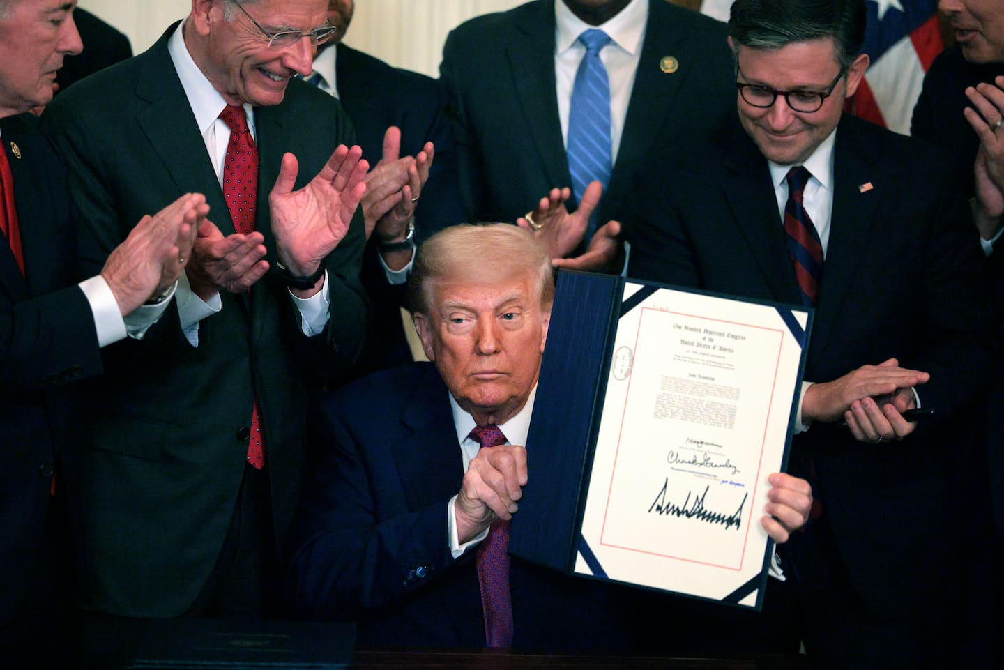 US President Donald Trump, joined by Senator John Barrasso, Speaker of the House Mike Johnson and other lawmakers, holds up an executive order after signing a series of bills related to California’s vehicle emissions standards. Photo / Getty Images
