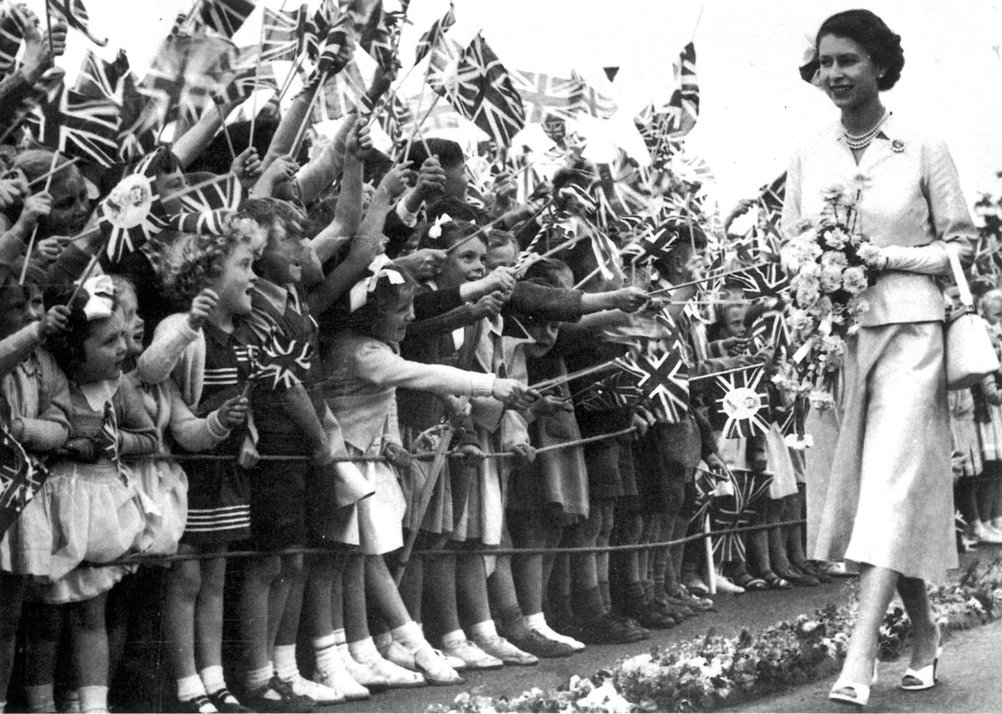Excited children cheer at a smiling Queen Elizabeth at a children's gathering at Wellington's Athletic Park in January 1954. Photo / File
