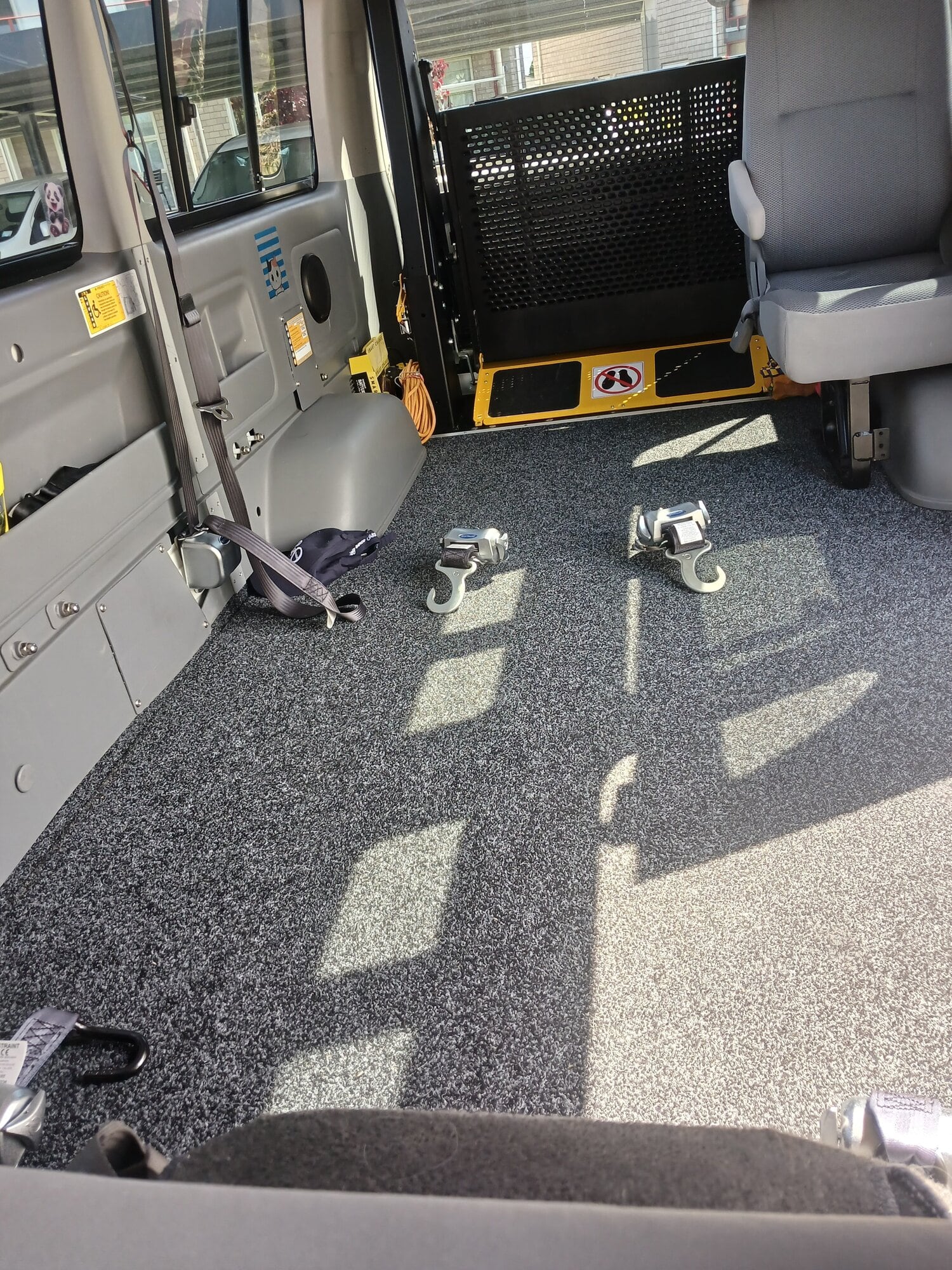 The hooks in Michelle's mobility van that lock her power chair into place.