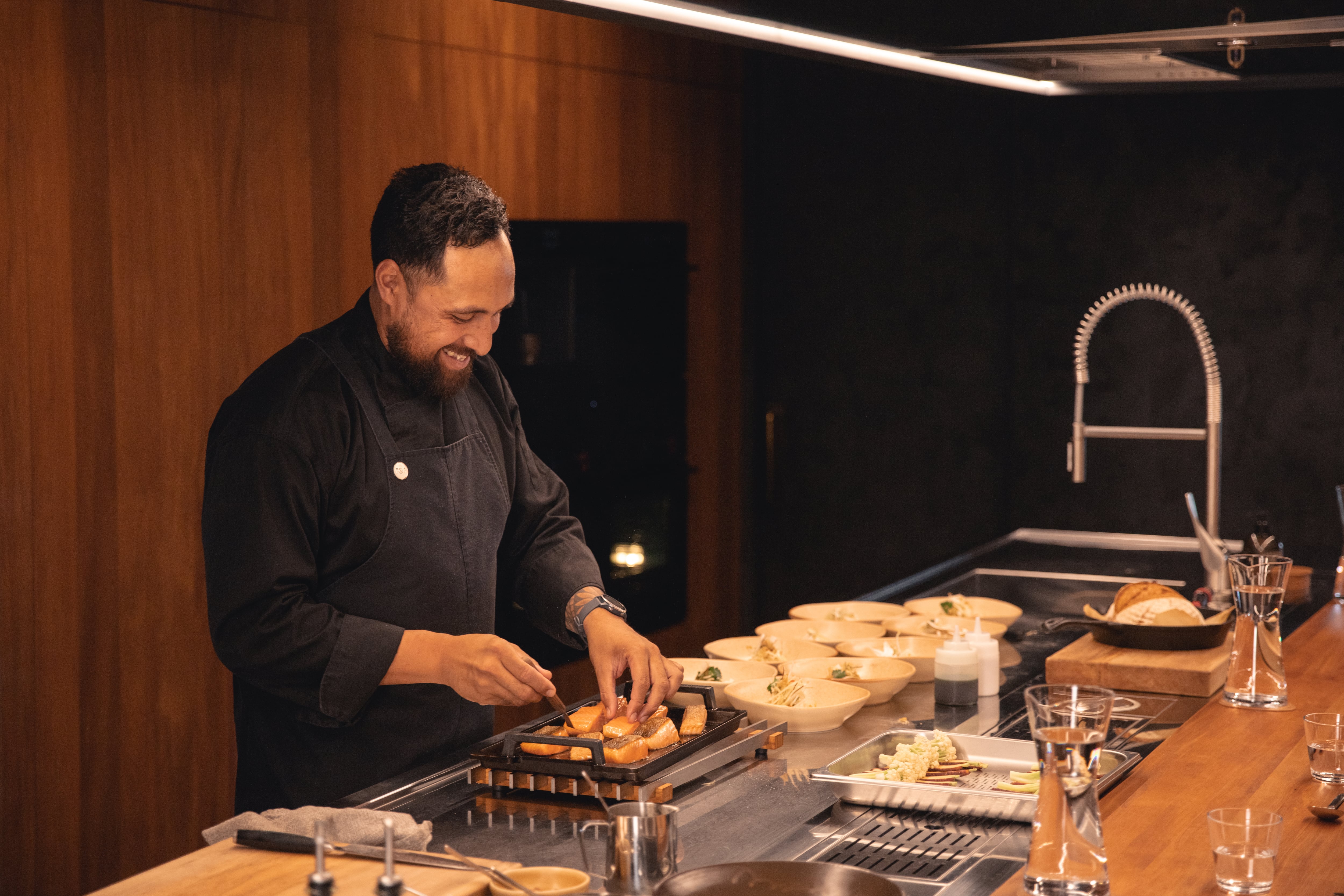 A chef preparing a dish using upcycled fish skins in a modern restaurant kitchen.