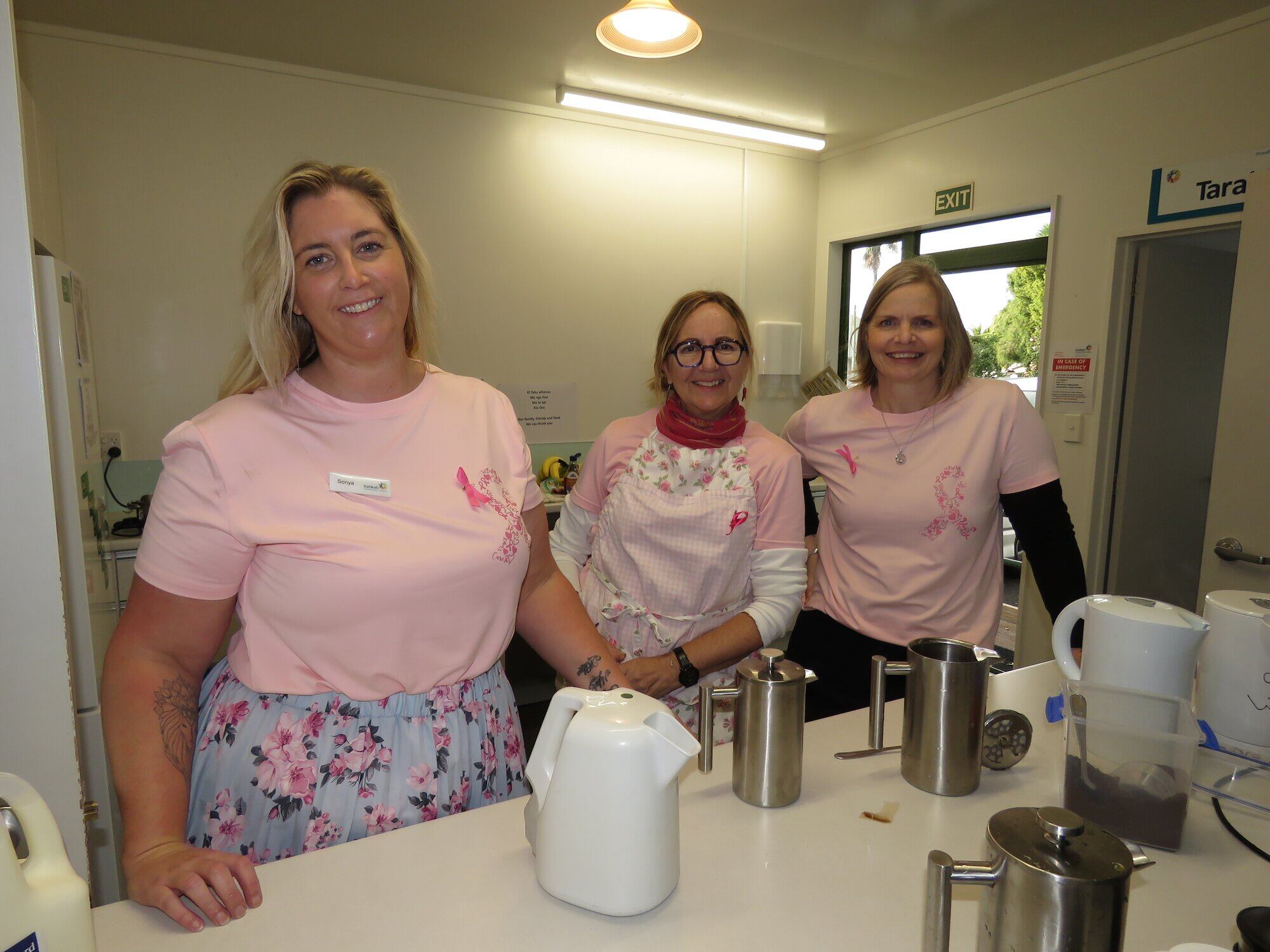 Katikati Community staff Sonya Mischewski, Lucy Valley and Sjaan Rounds cooking up a storm for the pink breakfast fundraiser. Photo / Merle Cave