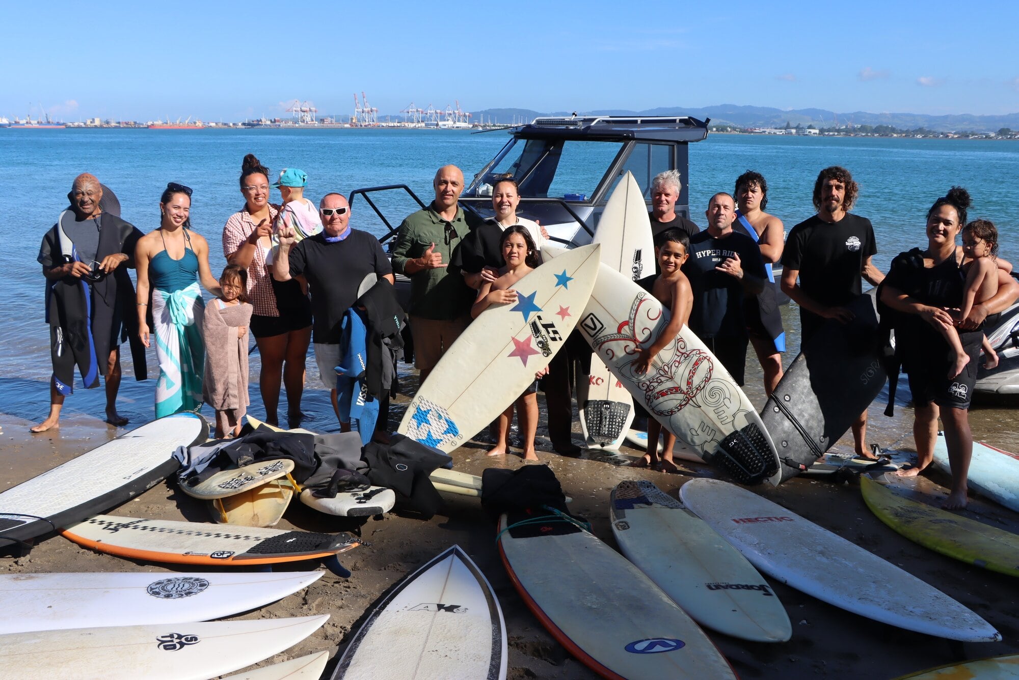 Matakana kaumātua, Bay Boardriders and Te Kura o Te Moutere o Matakana school representatives: Te Kehu Kehu Butler (left), Emoana Consedine, Te Aoreke Murray, Maraeatia Gardiner Toi Murray, Ihaia Murray, Phil Joseph, James Jacobs, Ripeka Murray, Hori Murray and Nuku Williams (holding surfboards), Dean Wearne and Cale Tolley, Te Taiwhenua Murray, Travis McCoy, Levi Henry, Te Kaweroa Murray. Photo / Ayla Yeoman