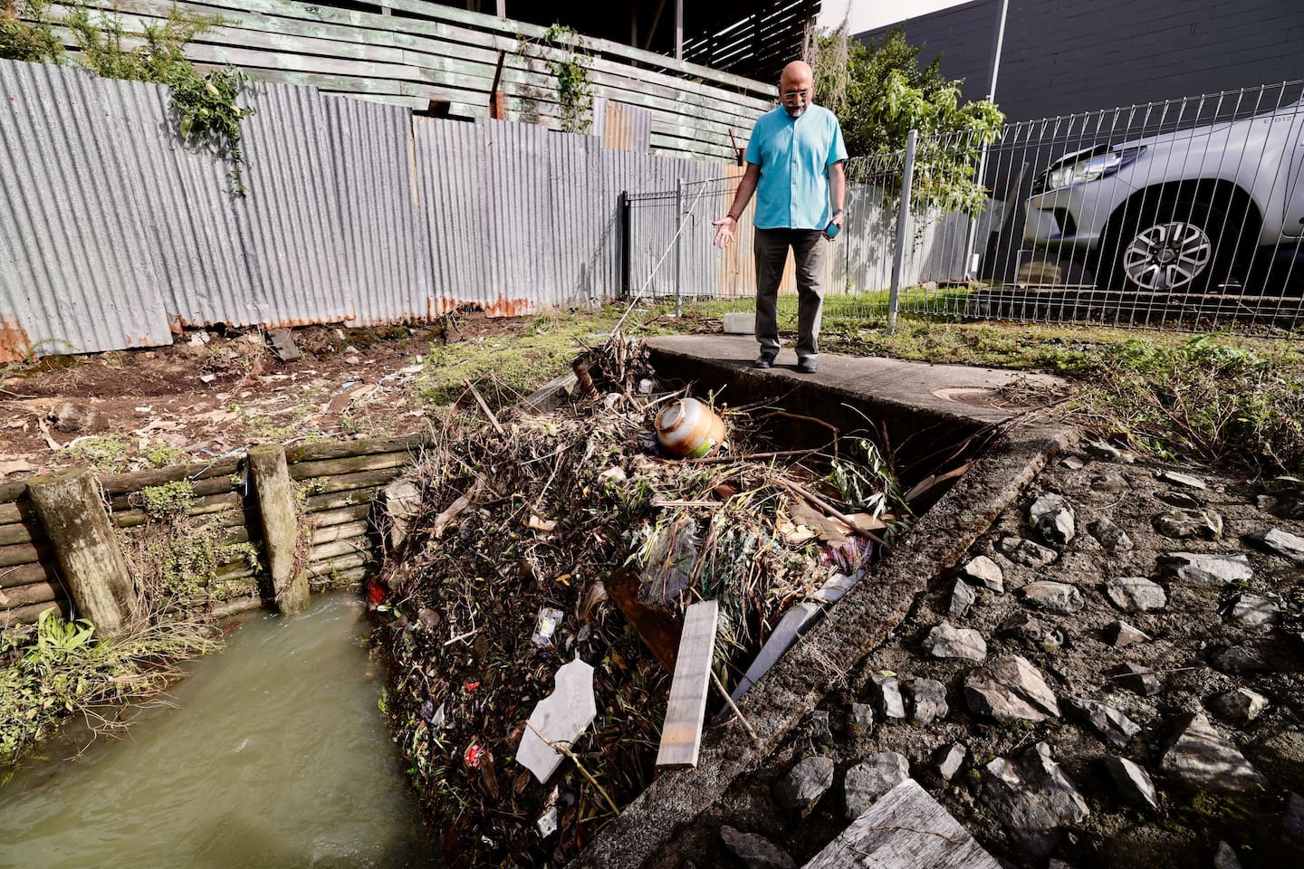 Harish Lodhia inspects a blocked culvert in the creek below his Stoddard Rd property in Mt Roskill. Photo / Dean Purcell