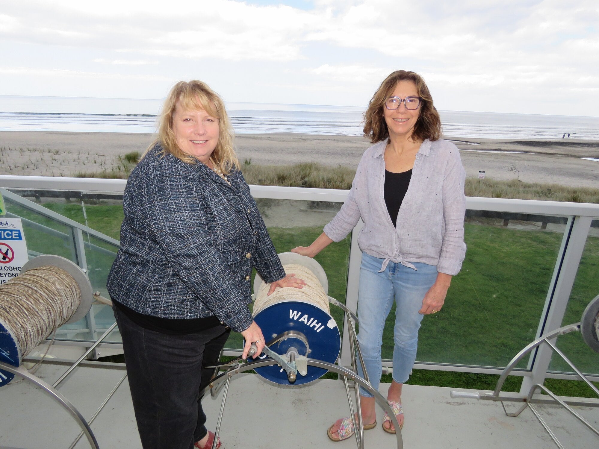  Waihī Beach Lifeguard Services Inc board chair Donna Pfefferle and director of membership Natalie Lloyd with one of the old rescue reels from the early days. Photo / Merle Cave