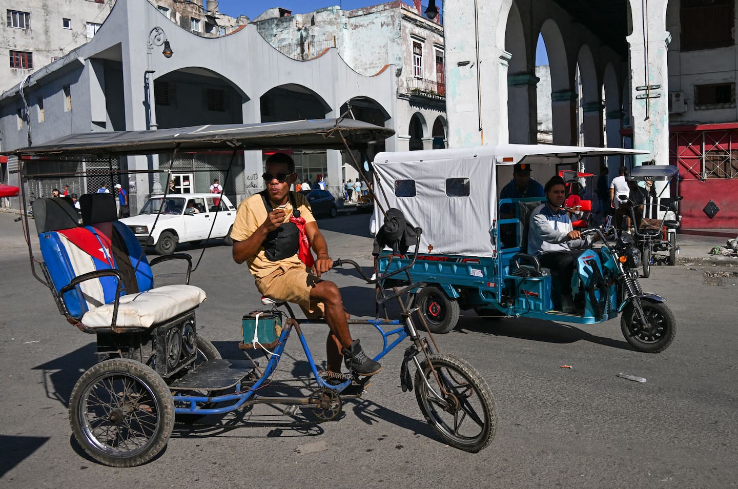 A bicitaxi and an electric tricycle are seen on a street in Havana, Cuba, on February 13. Photo / Yamil Lage, AFP
